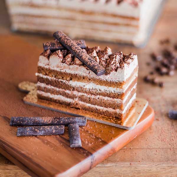 Layered chocolate cake resting on a cutting board.