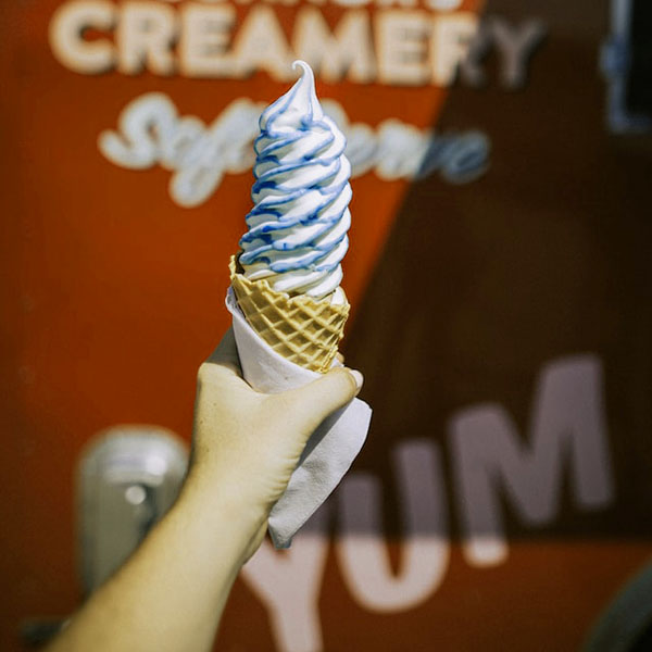 Person holding a blue swirl icecream cone.