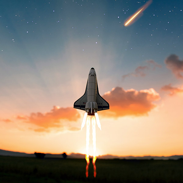 A spacecraft launching at sunset. There is a shooting star in the background.